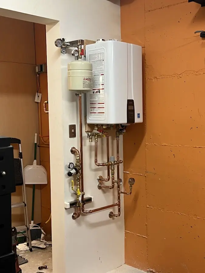 Plumbing technician inspecting water heater connections in Parowan